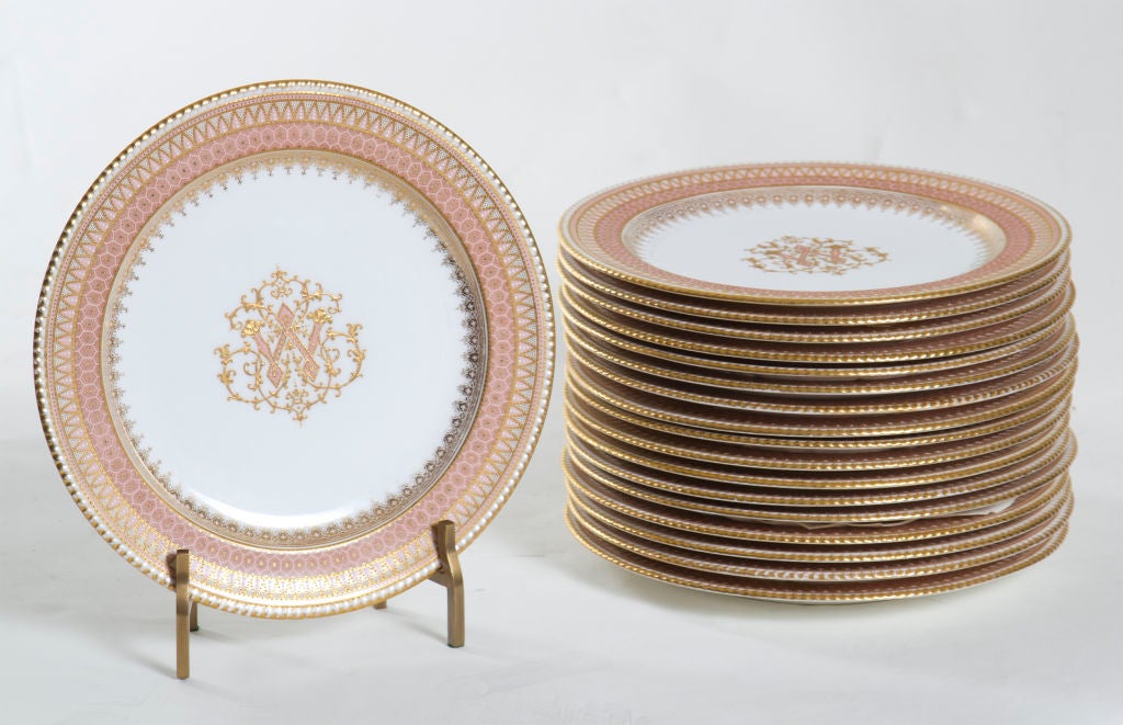 An elegant and long set of 18 Copeland gilt and enameled service plates made in England late in the 19th century.  The central medallion features the initial 
