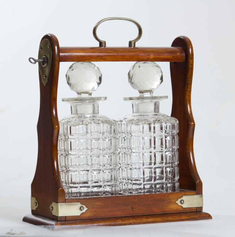 A classic late 19th century cut crystal decanter set in a locking oak frame with white metal mounts.  This is a great set and the perfect gift for someone with teenagers.