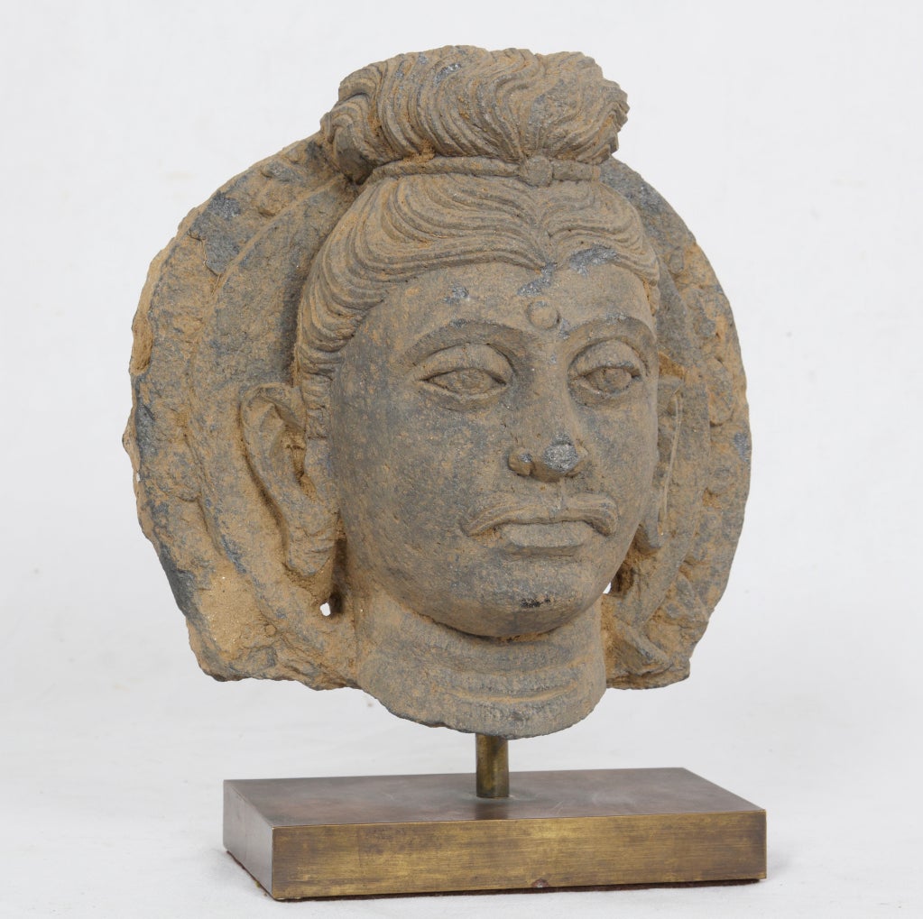 Kushan dynasty schist head of Buddha made during the 4th Century in central Asia.  These are some of the earliest representations of Buddha.  The artistic style incorporates influences brought to the region by Alexander the Great and his armies. 
