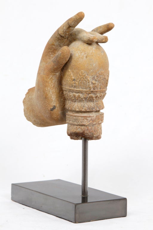 An elegant fragment of Vishnu holding the cosmic egg in sandstone on a later custom metal stand