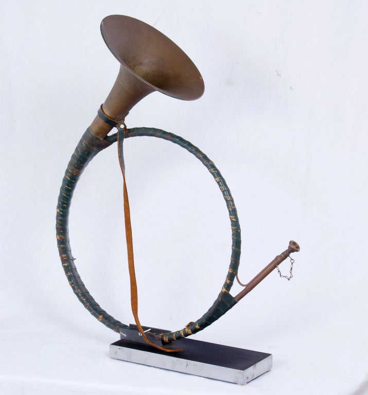 A decorative and large English brass and leather mounted hunting horn made durin the first part of the 20th century.  The horn wrapped in worn green leather.  Mounted on a custom polished steel stand.