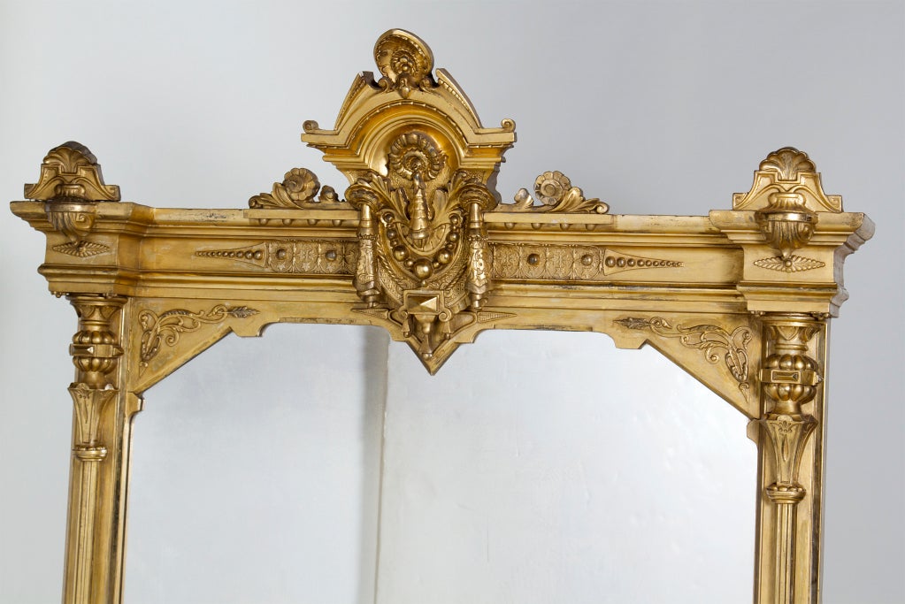 This large and richly gilt mirror was most probably made as a display of wealth for an American Victorian mansion.   Generally mirrors like this where used in formal entry halls.  Probably much too large to fit over a fireplace.  Might look great