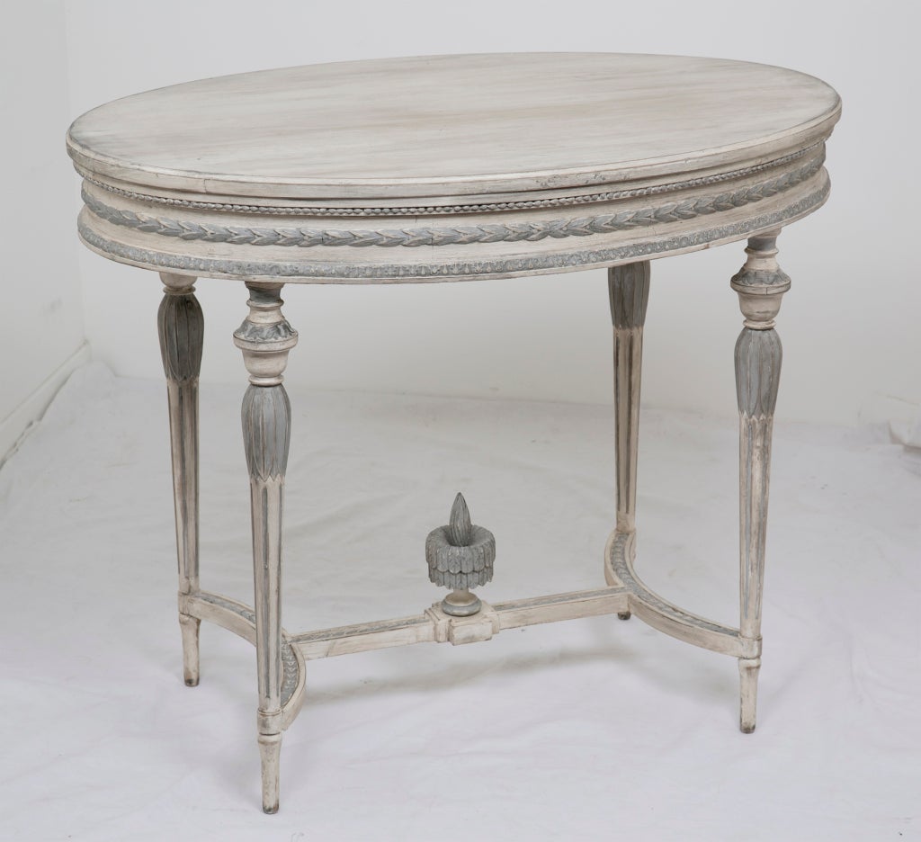 A great neoclassical Swedish gray.           and white painted oval table in Louis XVI style.  Good scale with nice carving and a good later painted finish.