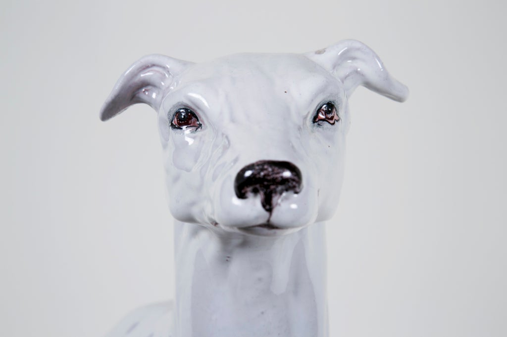 A classic vintage Italian glazed pottery dog sitting at attention on a 