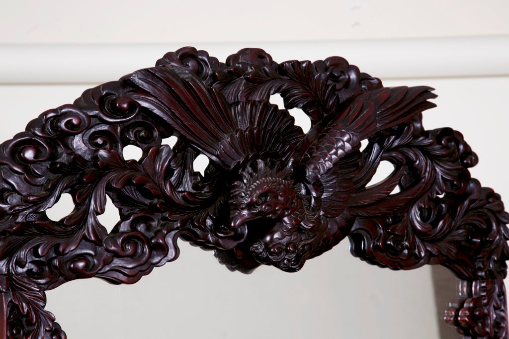 Carved all-over with dragons and flowers. The handles are carved raised peonies. The mirror is supported by two dragons and crested by a large Phoenix. This piece reflects a mixing of Western chest with Asian decorative elements. This took a skilled