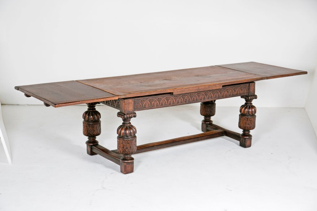 A wonderful and large English oak draw-leaf table. This design was first made during the Elizabethan period. This table dates, circa 1900. Since it was photographed we have had the top polished to match the base and we have had the frame glued and