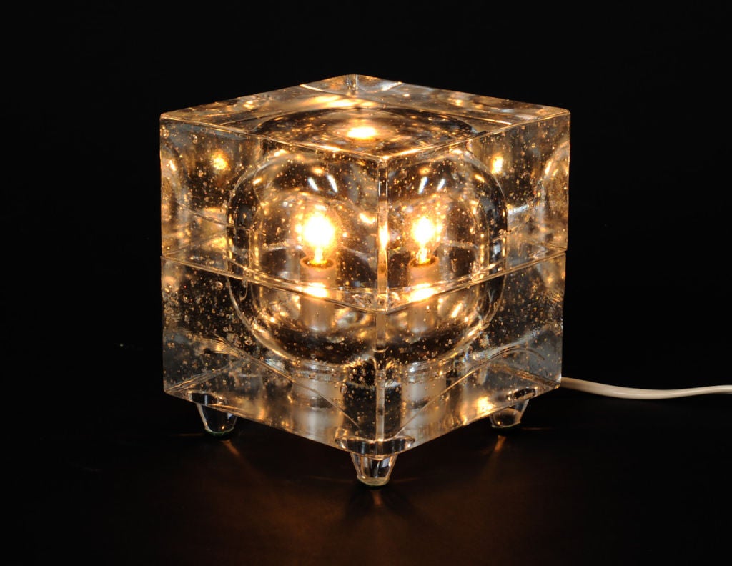 A wonderful solid glass cube light. This desk lamp is  very sculptural and heavy bubble glass.  The light has a european plug and socket but comes with a converter and reducer so it can work in americian sockets.