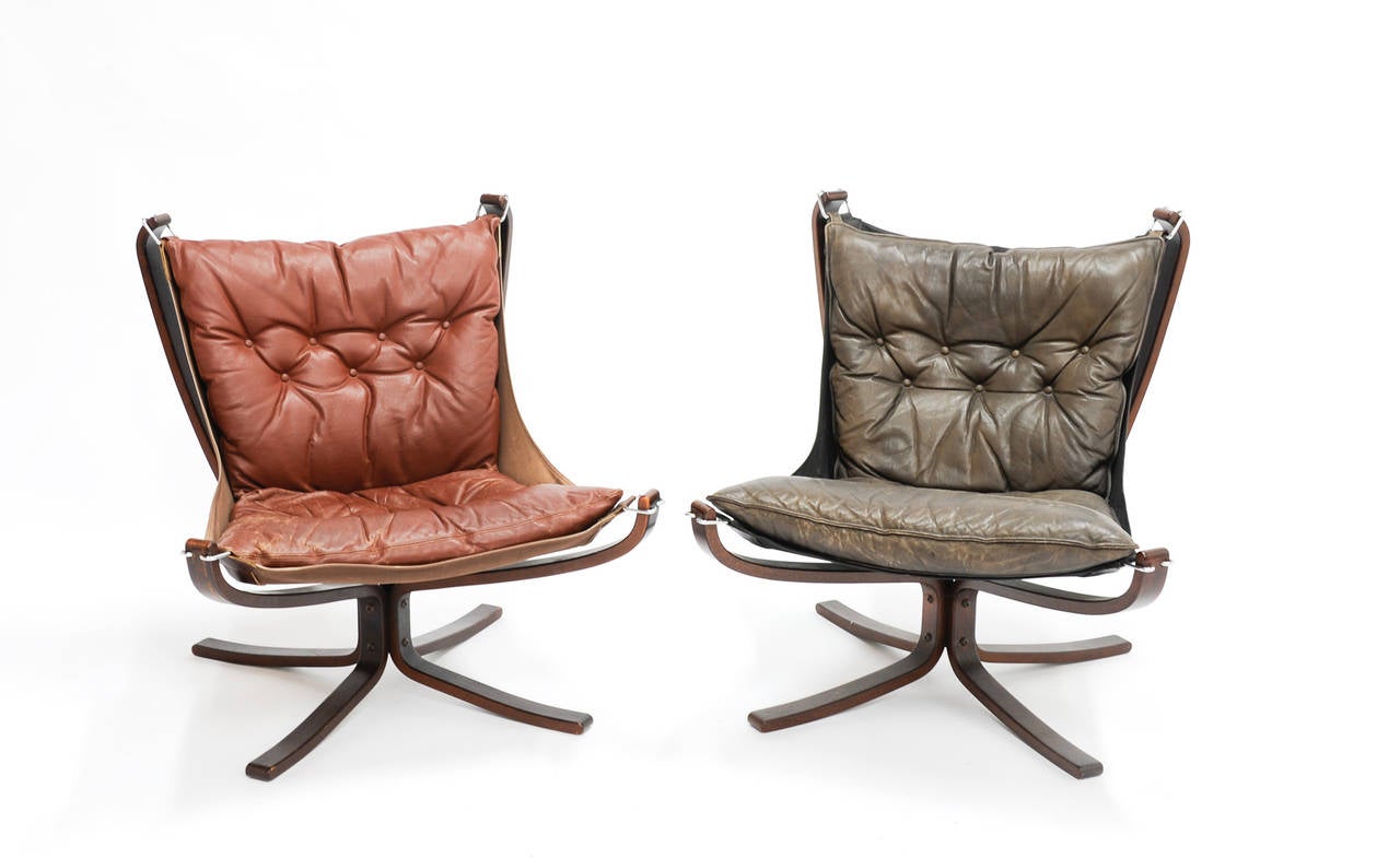 The Falcon sling chairs by Sigurd Resell. This version is in rosewood and leather. The seat is suspended from the frame to encourage relaxation Slings and leather don't match in color.