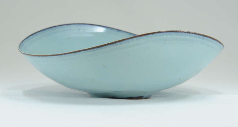 A wonderful bowl by the talented spousal team of Gertrud and Otto Natzler. This bowl is a very refined piece of pottery in one of their most handsome glazes. The thin edge is a wave pattern after the beauty of the Pacific Ocean.