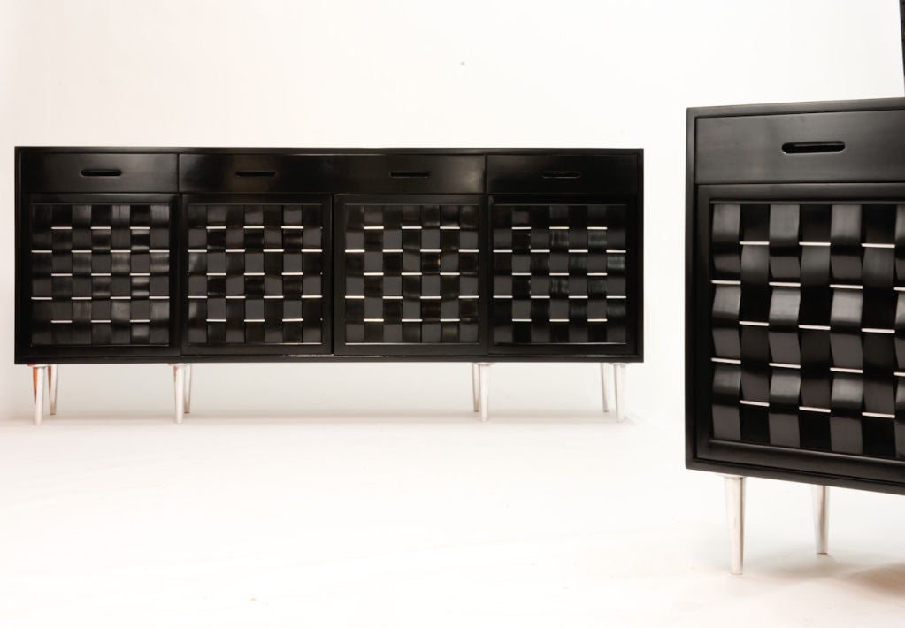 An Edward Wormley woven front cabinets for Dunbar done in a black lacquer finish with a bleached mahogany drawer fronts. The woven door fronts were weaved with aluminum rods matching the aluminum legs.