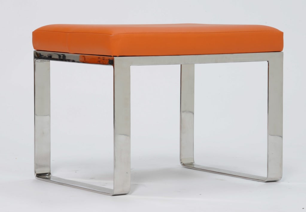 A mirror polished stainless steel bench with a soft danish leather in the Hermes orange.