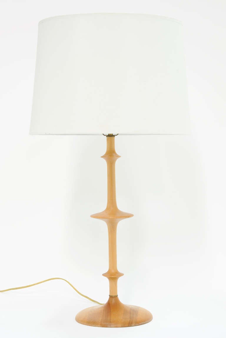 An elegant and simple pair of maple turned artisan table lamps with a brass ring connector.