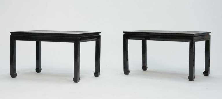 A stylish pair of end tables in the manner of Paul Laszlo with 'floating' leather tops.  Refinished in black lacquer.  Stunning, understated elegance.