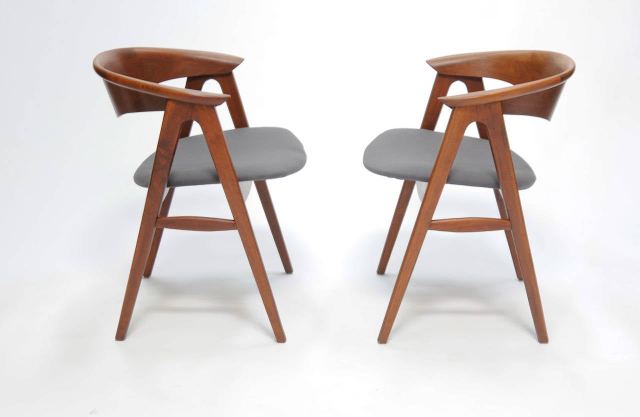 A pair of Erik Kirkegaard captain chairs for DUX. The teak chairs are the rare larger version of the chairs.