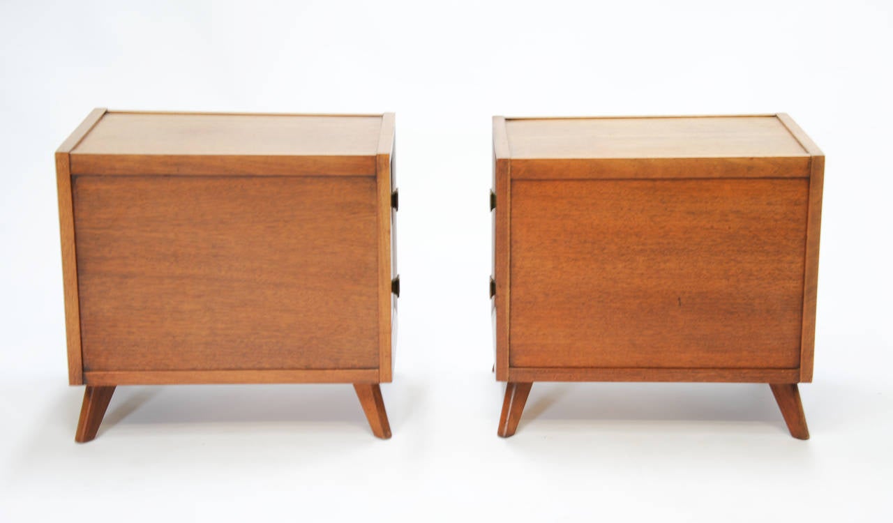 A Pair of mahogany nightstands with brass pulls in the manner of Grosfeld House design company.