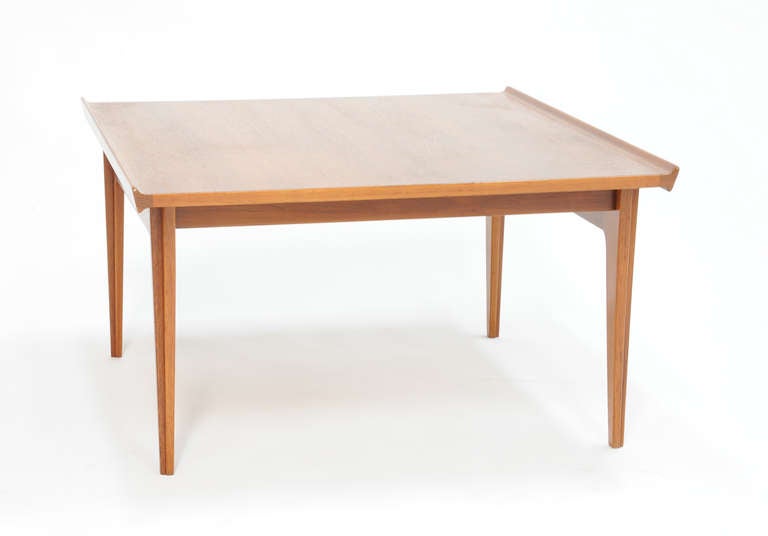 A wonderful teak end table by Finn Juhl for Frances and Sons. The knife edge shoes the refined eye of Modern Master Finn Juhl. The tappered legs andrefelctive of the edged top.