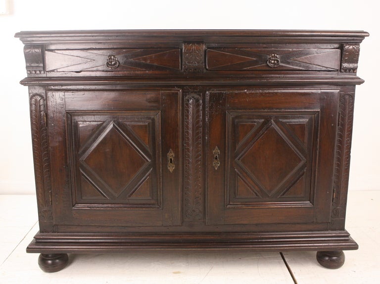 A 19thC rich, elegant console, so lovely, this would be very unique used in an entry.  As a dining room storage cupboard, it offers inside storage, and has two drawers as well. The carving is in the style of 17th C Jacobean and is a dramatic look. 