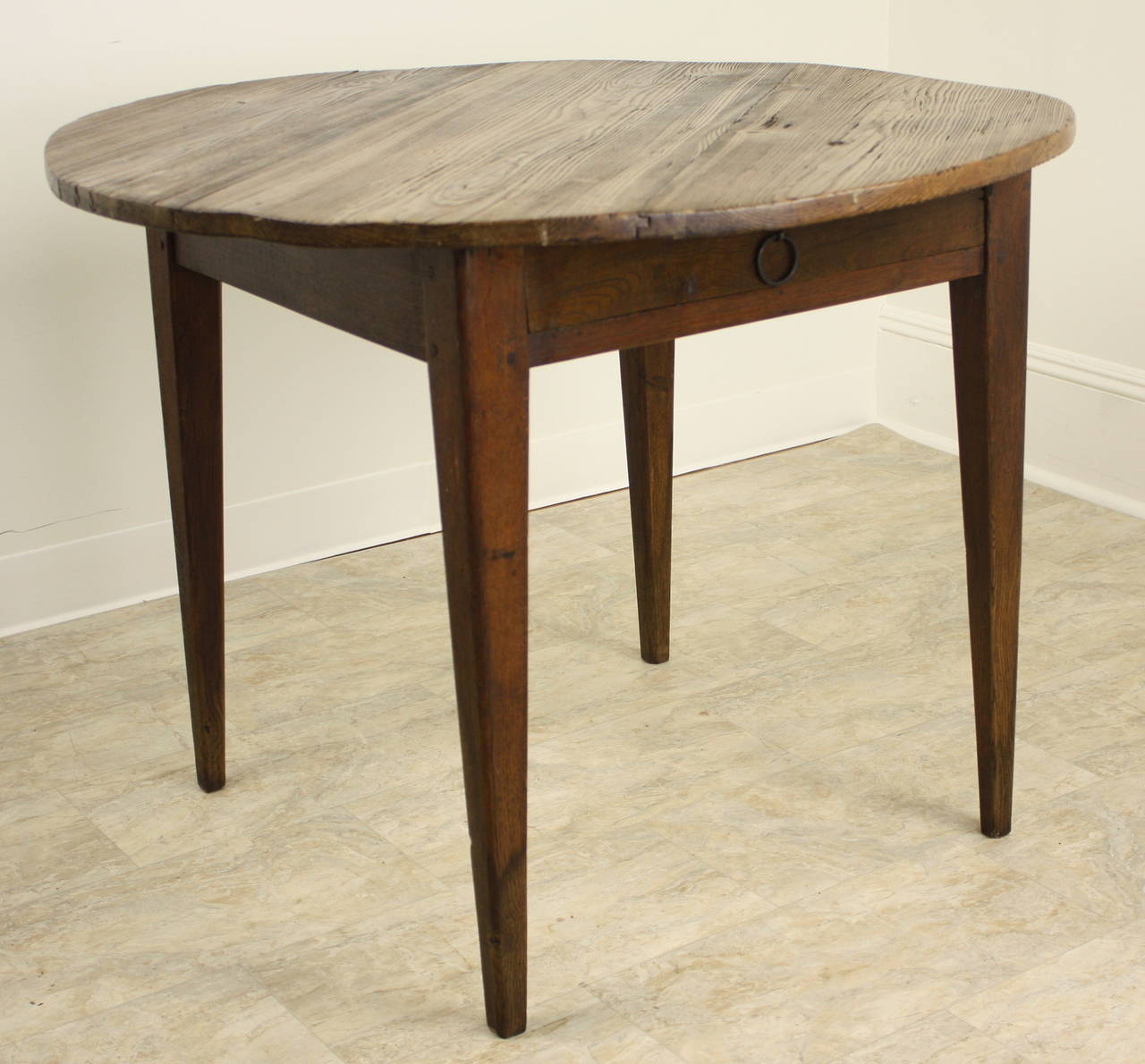 An antique round occasional table from France. A great country look, with farm table style legs.  A little low for a breakfast table att just 28 1/2