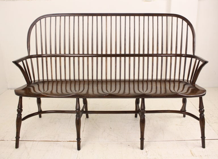 Very elegant three-seat bench, hand-crafted in England for Briggs House Antiques.  Lovely crinoline stretcher base and classic Windsor features.  Lovely rich oak color, very comfortable and sturdy.