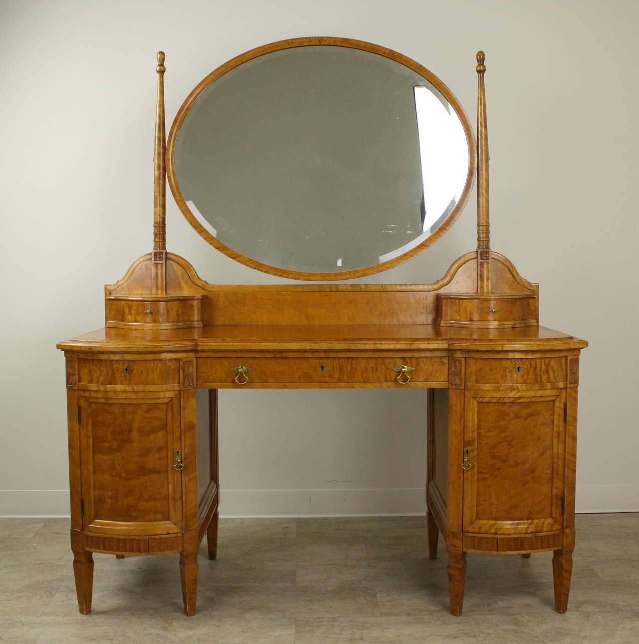 This dramatic vanity is classic 30's, it is easy to see the deco influence.  Very finely made, on the Continent, it is dramatic and imposing.  Carved moldings, wonderful little serpentine shaped drawers, a grand mirror, all seem meant for a movie