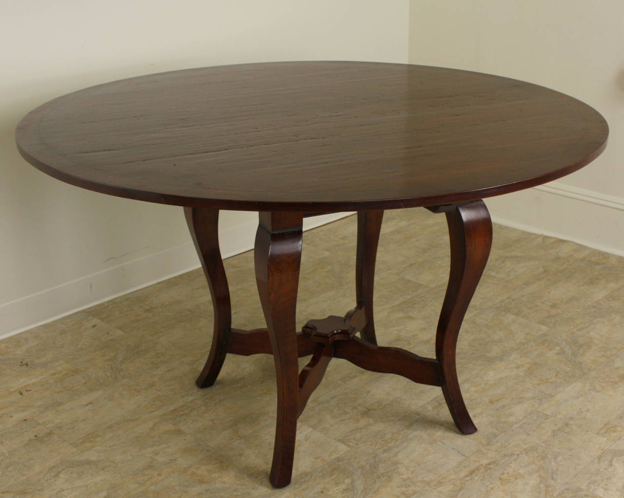This custom made table is an elegant look, imported from England in a rich dark cherry with a very nice banding around the edge, delineated by a slender ebony stringing.  The color is lovely as is the grain and patina.  The four handsome criss-cross