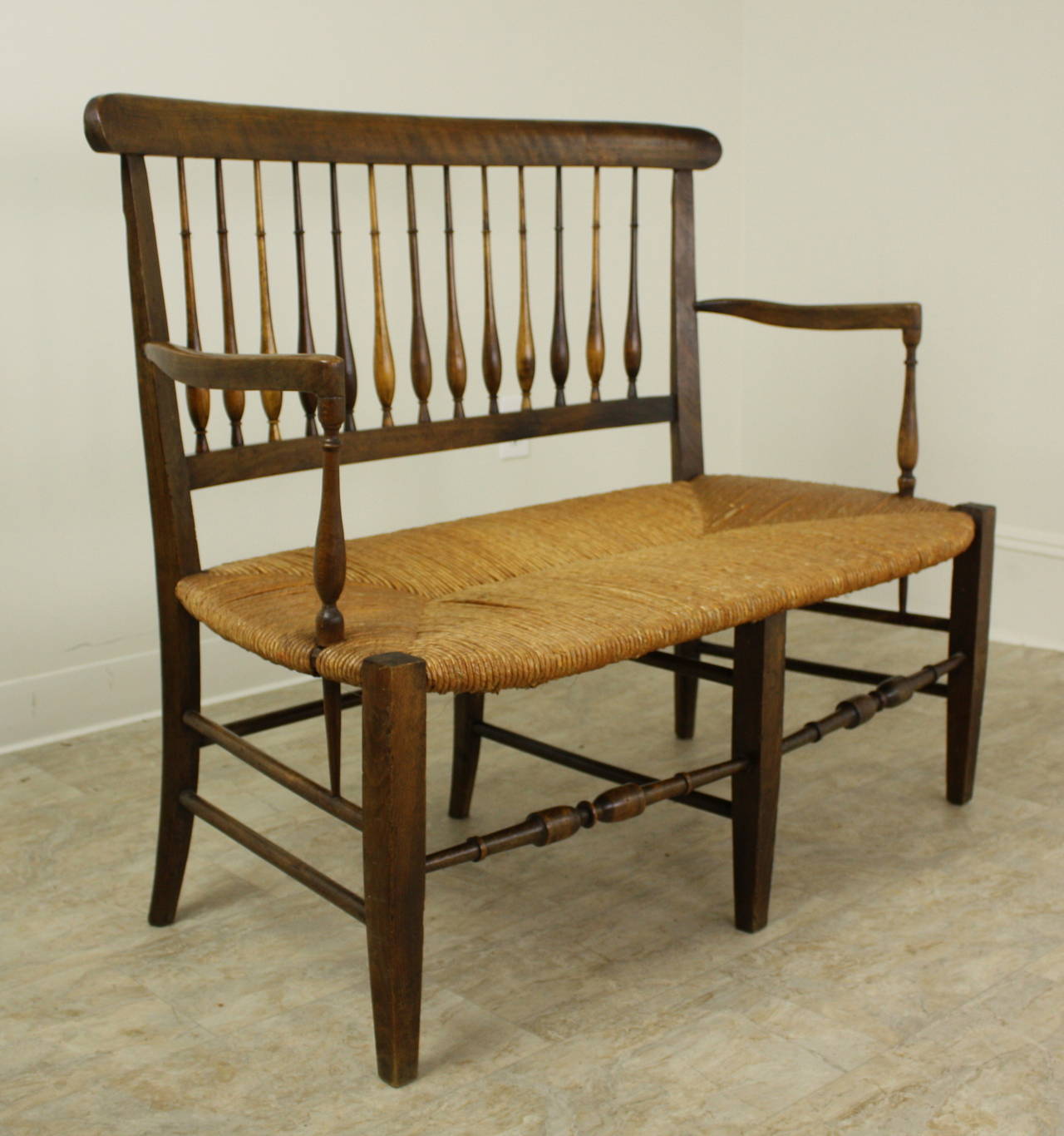 A delightful little two seater bench, the wood frame is a lovely warm color fruitwood.  The carving overall is very well done, with spindles across the back, shaped and carved support stretchers on the base, for good and steady seating.  Turnings