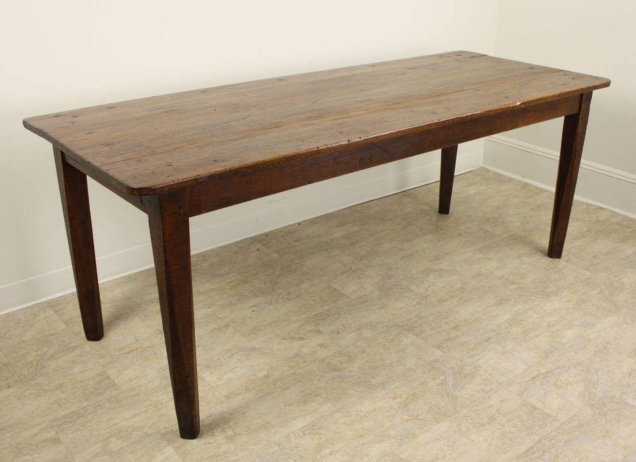 The table is a warm rich pine,  very pretty, and has attractive wear and distress.  The rounded corners on the top is somewhat unusual, and offers an extra benefit to a big table top.  One drawer on one end.  The legs are nicely tapered, and the
