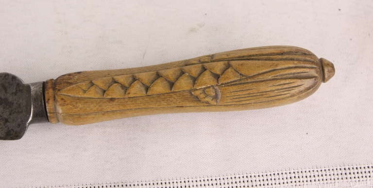 An interesting collection of four bread knives, handles carved with wheat sheaves, flowers.  Blades are well worn, but easily sharpened.