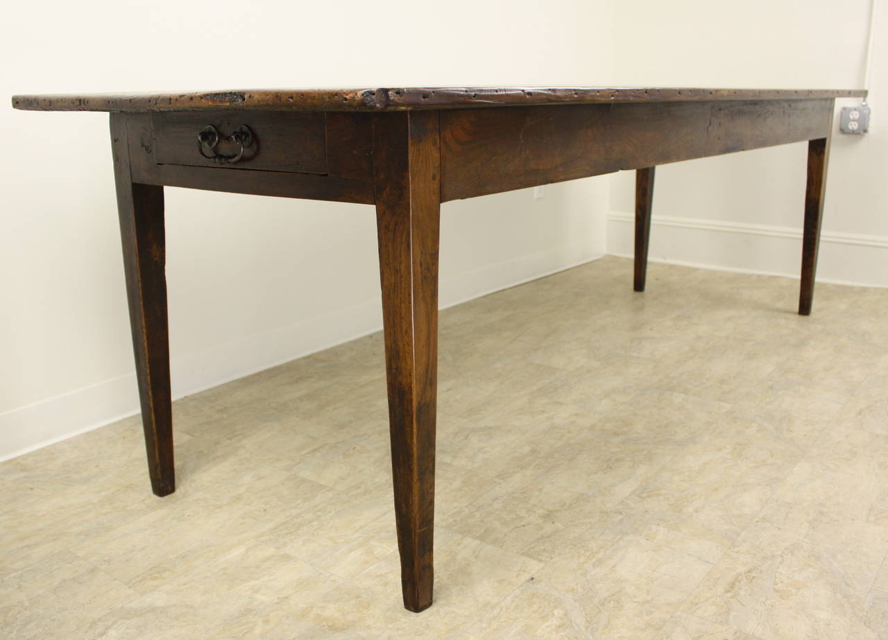 A lovely long country table, the length is great and allows four chairs comfortably between the legs on the long sides. The legs are Classic, long and slender and are very attractive. The color overall is a lovely rich pine, with a very nice patina.
