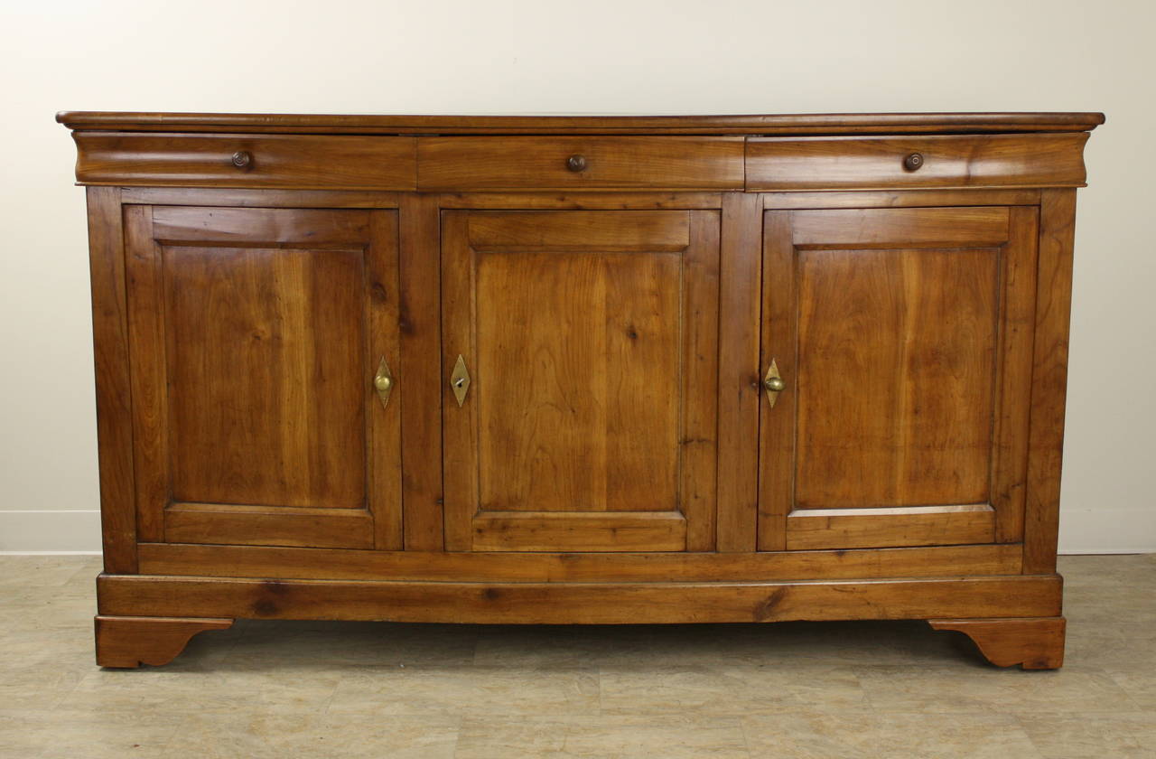 This is a wonderful example of the Louis Philippe style, with shaped drawers, set-in panels on the doors and sides, and perfectly shaped feet, which are very lovely.  The lighter, warm cherrywood color is rich in patina. Good storage, and terrific