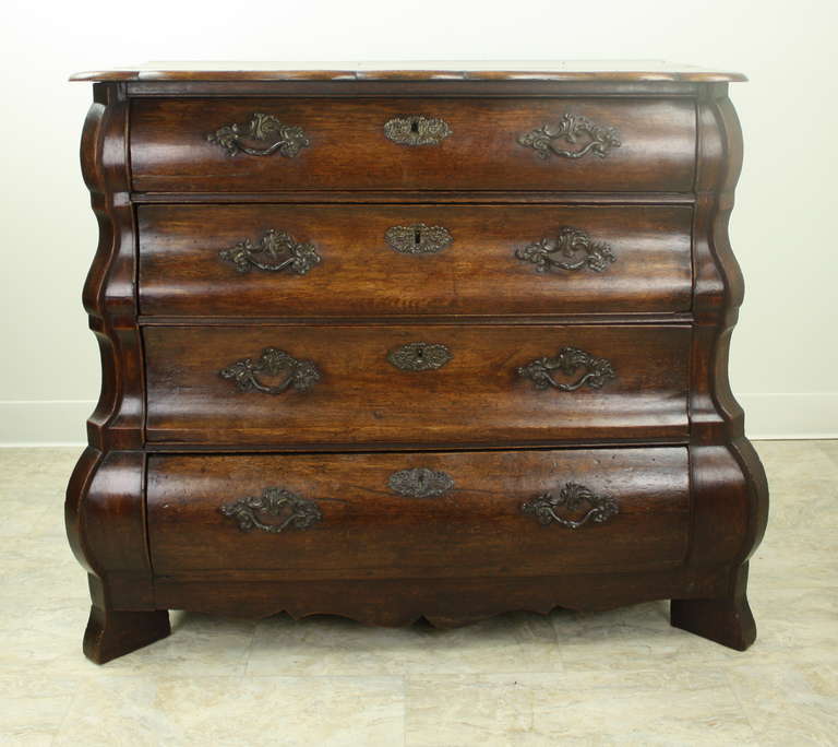 At home in the most elegant surroundings, this chest of drawers is stunning. With the lovely shaped top, and the visual movement to the drawfronts, framed by the shaped vertical sides, it is extremely desirable.  Original handles and escutcheons. On