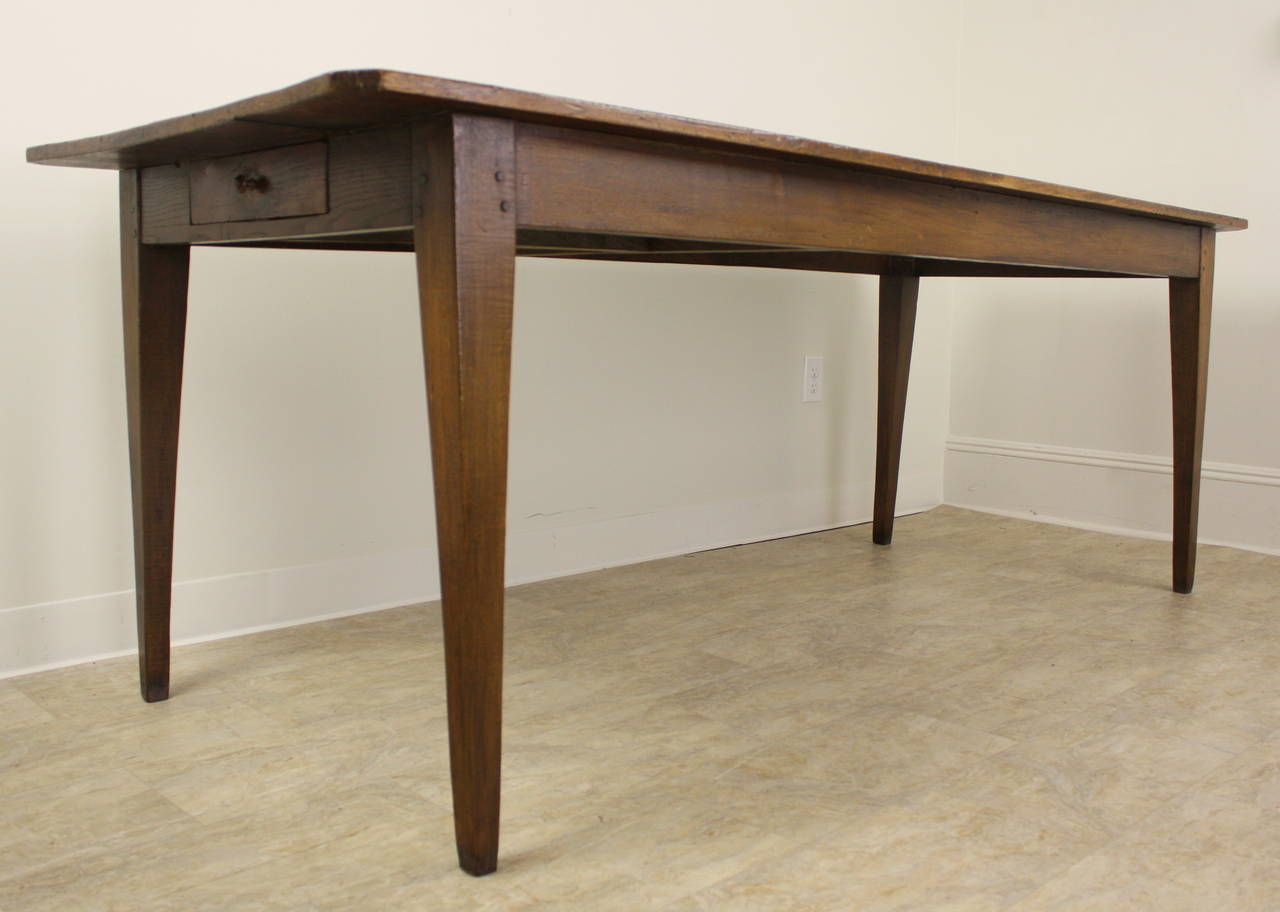 This is a great looking table with excellent dimensions.  Lovely slender tapered legs, pegged at the apron, are set near the ends of the top, allowing good seating between the legs on the long sides.  Color and patina are quite pretty.  There is one