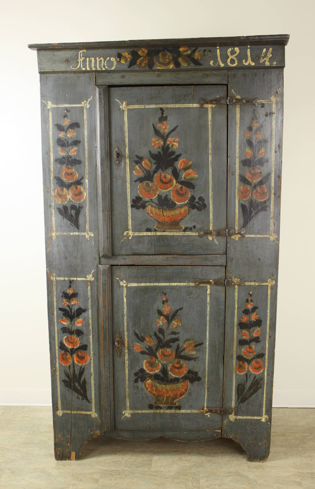 The charming bouquets of this piece are all original paint, on a stunning blue grey background, with original handwrought iron hinges and wood pegs. The upper door lock is very unusual; the lower door lock was replaced, but quite some time ago. The