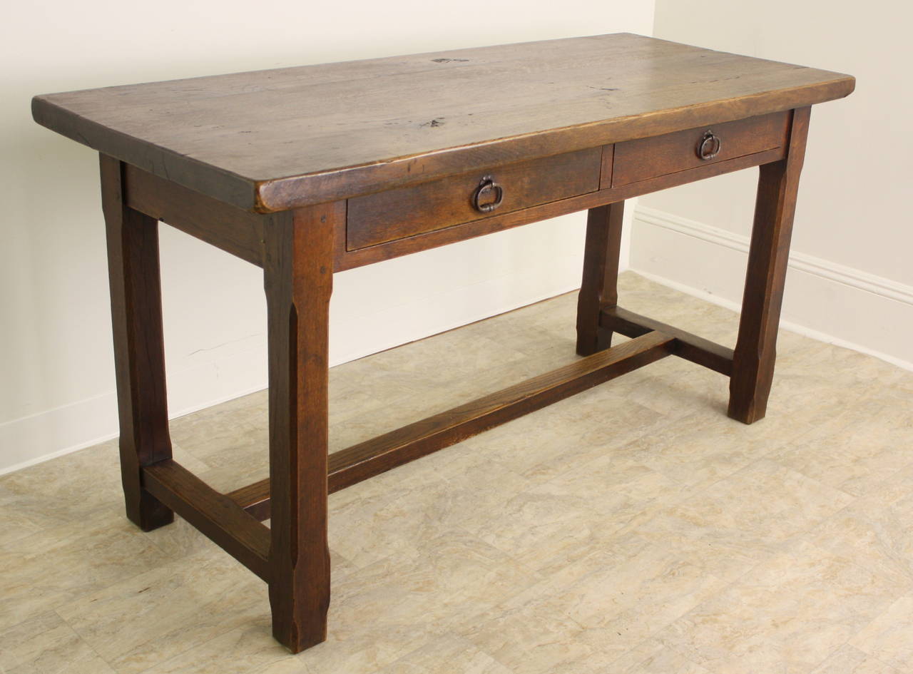 This is a very nice chunky server in a well-patinated oak, highlighting the warm rich oak color.  There are two drawers in the front apron, with hand-wrought iron ring handles, and the entire look of the piece is enhanced by the sturdy legs and the