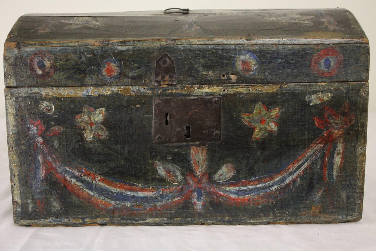 Charming early painted large wedding box, with flowers and ribbons, in beautiful colors, on a dark charcoal-color base paint.  The delightful hand made hinge to hold the lid open, and the little carry handle, are sweet.  A little part of the lock is