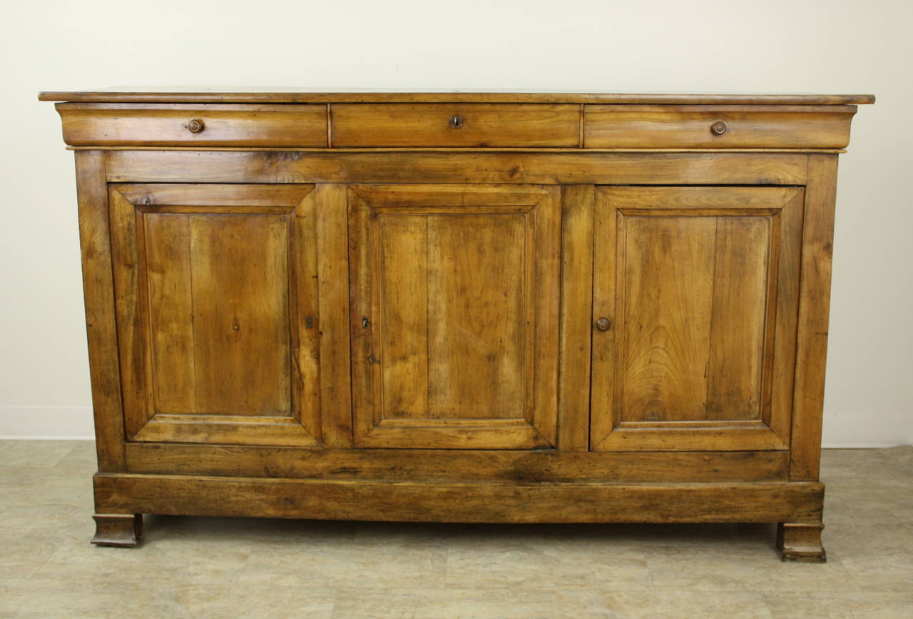 This very lovely cherry sideboard is a traditional Louis Philippe shape, note particularly the classic feet and the shaped drawers. The outstanding element of this piece is the wonderful cherry color, beautiful grain and the very good patina.  Lots