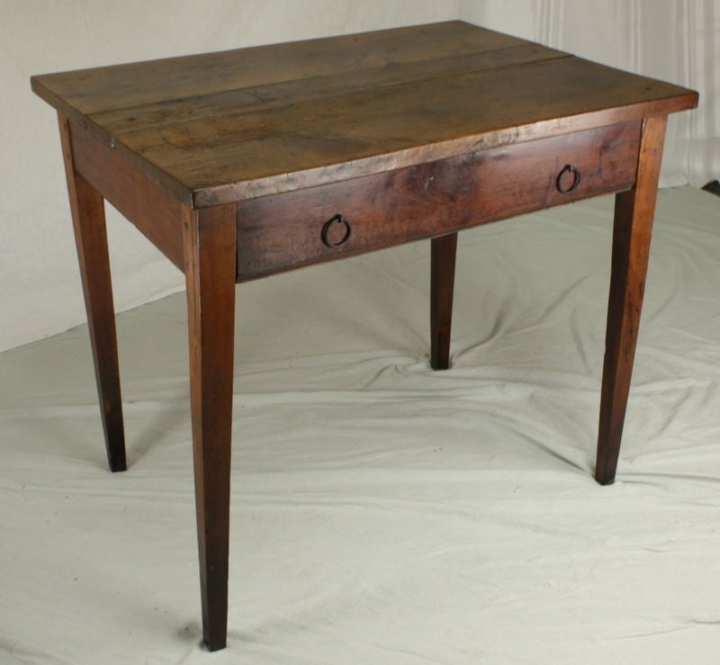 A small antique writing table from France. Made of cherry with a rich color and patina. This end table has a very nice thicker top. One large drawer with ring pull handles. Legs have been raised to a more useful height. Apron height for knees is 24