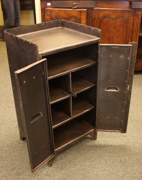 A French Steel two door industrial steel cupboard from the 1930's.  Extremely cool, the doors and sides of the piece are accented with small decorative rivets, while the six interior cubbies provide excellent storage.  The 3