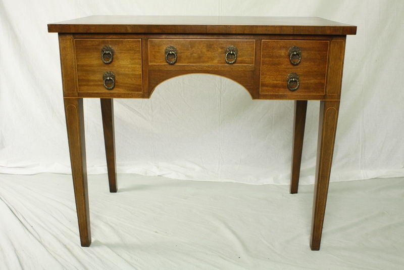 A lovely antique Georgian mahogany lowboy from England. Very simple and elegant. Note the attractive inlay on the legs and top and the crossbanded edge on the top. The mahogany is a beautiful warm color with a pretty grain. Makes a suitable lamp