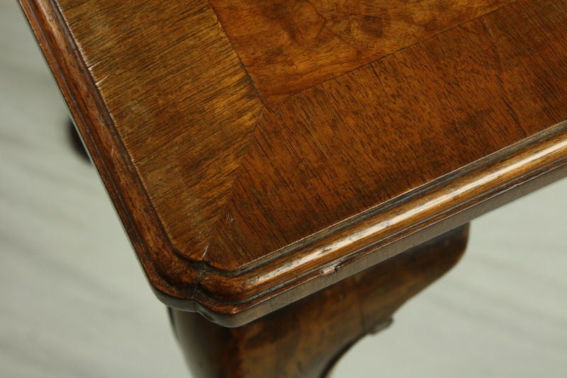 A Queen Anne style walnut side table with cabriole legs and pad feet.  A vintage reproduction, c1930s. The herringbone inlay and mitred corners add visual appeal to the top, while the delicate carvings on the legs give the piece a note of formality.