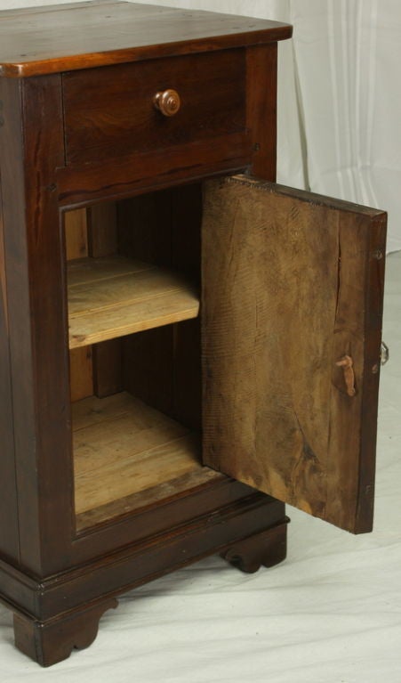 An antique small cupboard from France. Very pretty. Made of yew wood with a deep, beautiful color and exceptional graining and patina. The cabinet door opens up to a shelf inside. Perfect next to a bed, a nightstand, or as an occasional or end