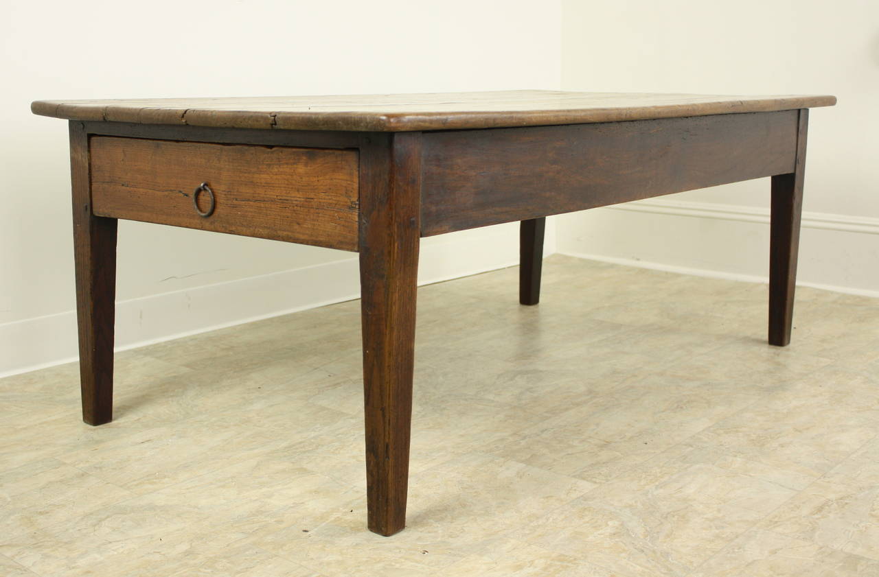This table has a lovely cherry top, with good wear, and some distress which lends lots of character.  The color and patina are very pretty.  Nice tapered country legs are very sturdy. One end drawer with a hand-wrought iron ring handle.