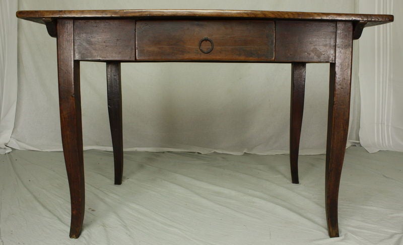 An 18th century writing table from France. Note the pretty cabriole legs. One drawer with an iron pull. Cherry is a rich, warm color; the top is slighly lighter than the base as shown in the photos. Apron height for knees is 23 5/8; could put 1/2