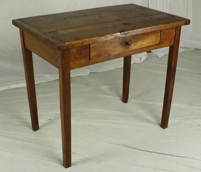 An antique occasional table from France, terrific thick top.  The cherry is beautiful, a rich color with wonderful graining and patina. Many possible uses as a small desk or writing table, with a 24
