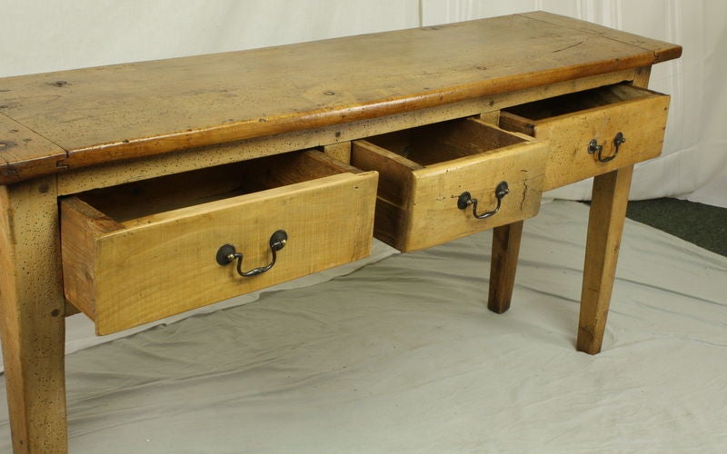 A handsome French antique sycamore console, scrubbed and polished to a warm glow. The thick top, breadboard ends and interesting graining add to the look.  Three roomy drawers measure 5