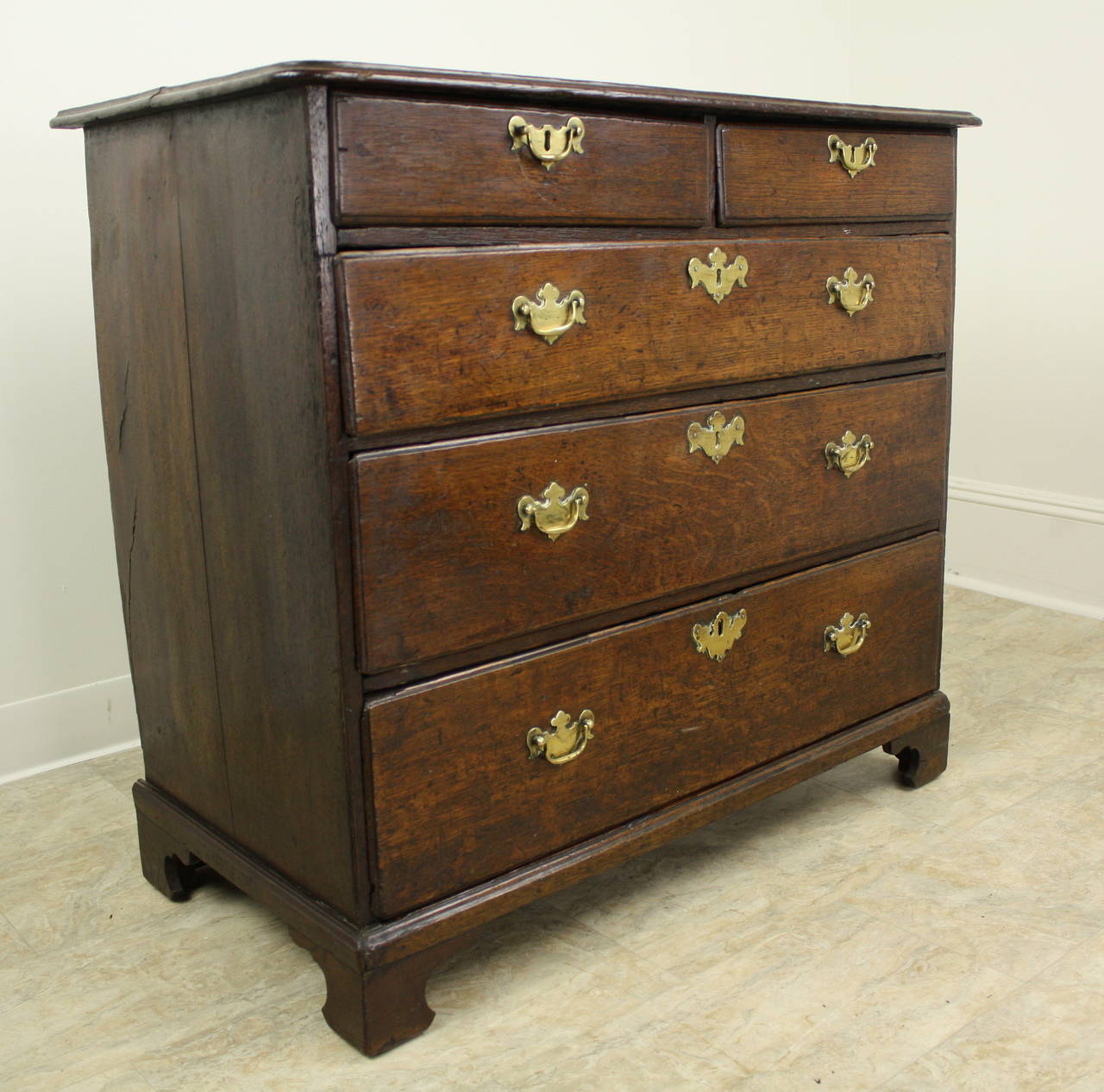 Beautiful original 18th century brasses are a highlight of the terrific early oak dresser. Two drawers over three graded drawers make this a Classic and very attractive configuration. The two-plank top and the gentle ogee edge enhance the overall