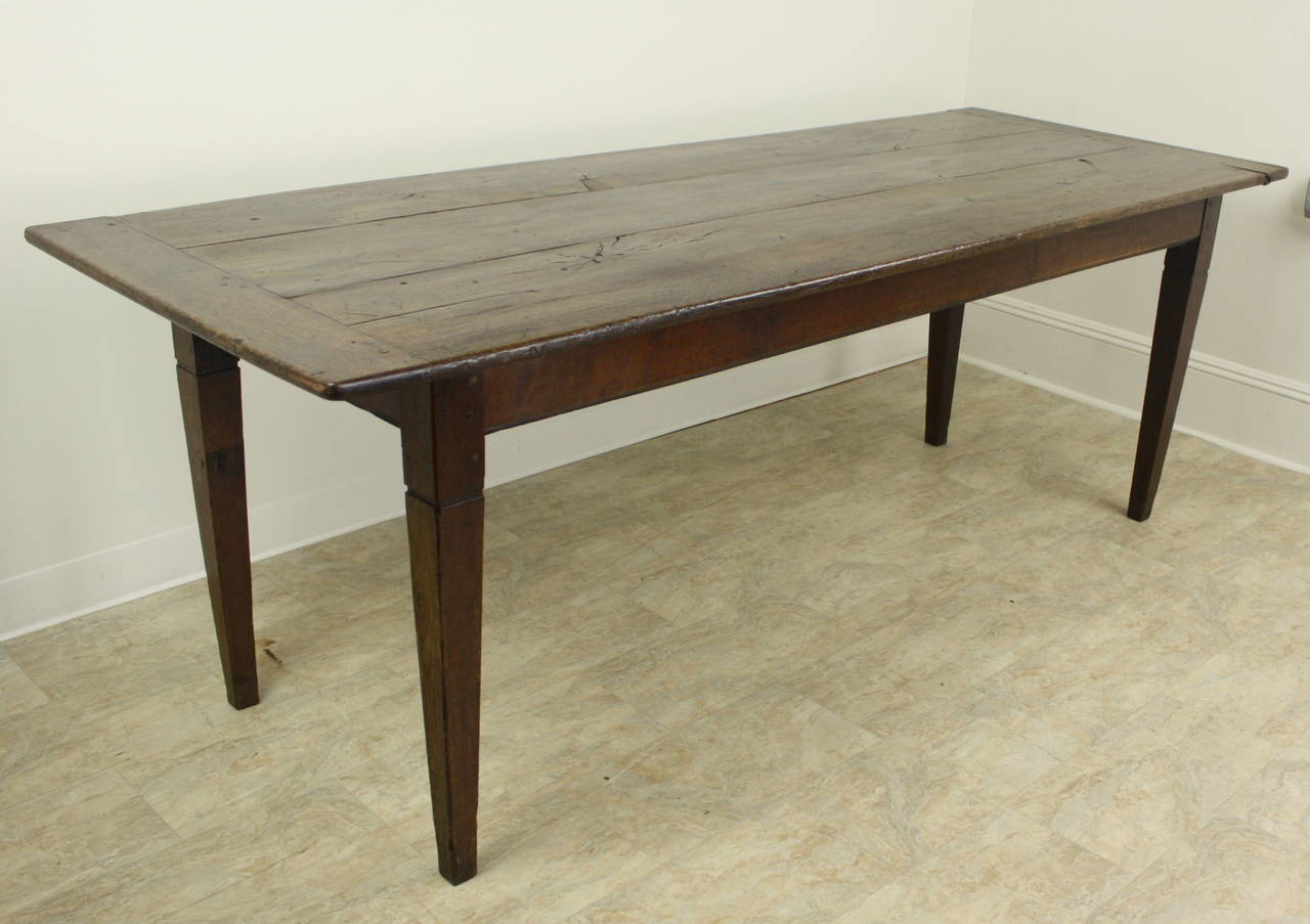 A great looking farmhouse table, with exceptional color and patina. The extra-wide bread boards on the ends are very nice and add a bit of a difference to the look of the top.  Good tapered legs.  Apron height is a comfortable 25