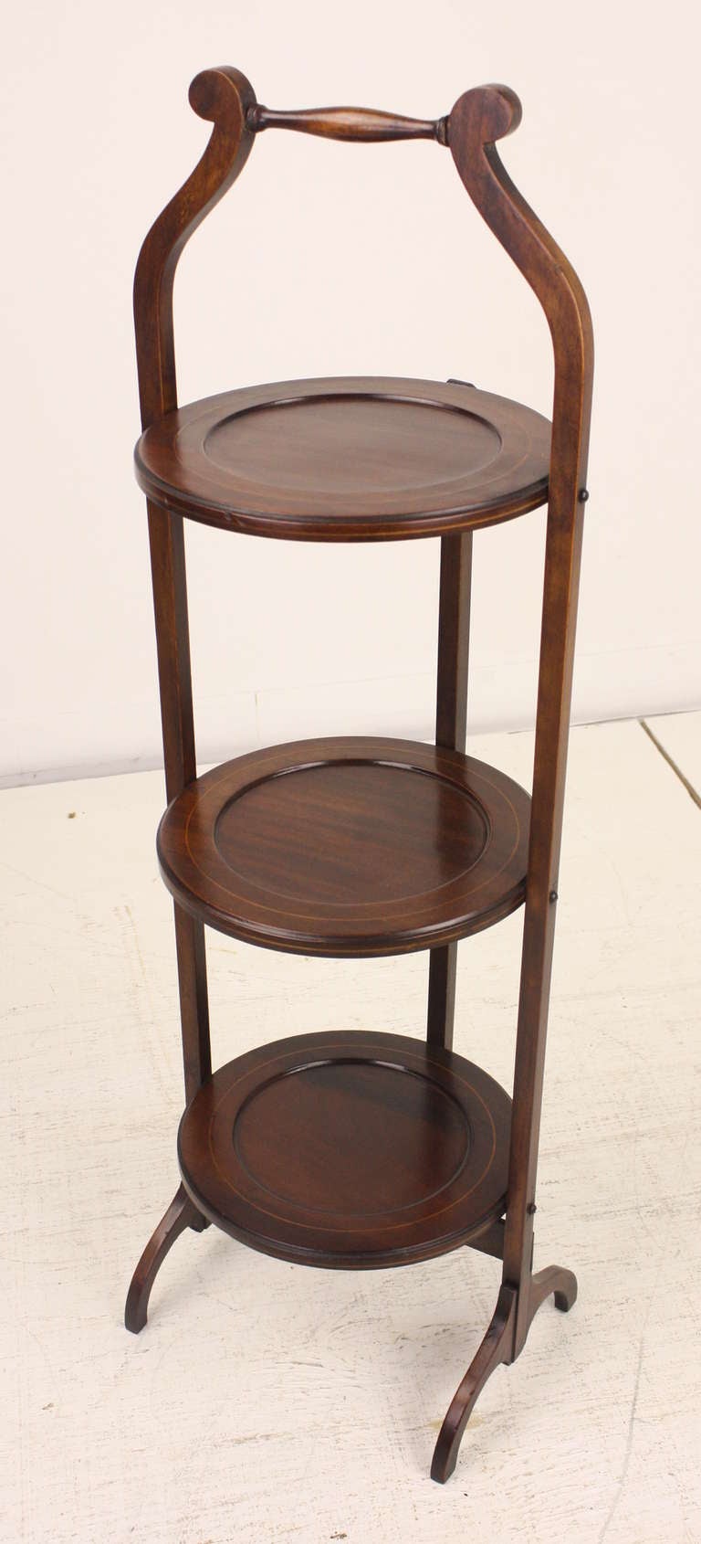 Very handsome, lovely mahogany patina. There is inlaid stringing in the border edge of all three plates. Folds up for storage and stays open when used for serving. Makes a good, small end table next to a chair, in a small space.