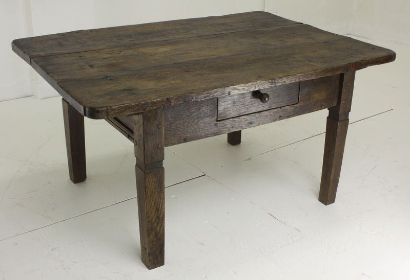 A rustic look, this continental coffee table, is charming, probably from Austria. A good piece for a country house, in a smaller room. Nice farm table style legs. The thick top gives an interesting look, in a nice strong dark color.