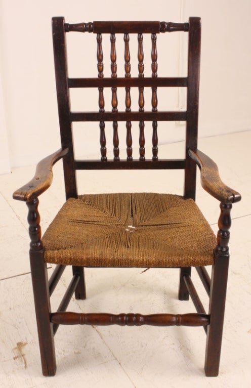 A beautifully patinated very early, period, country armchair. The oak is worn in a very desirable way, the arm fronts are lightened by the wear. The chair has a comfortably sized string seat, good height, and the seat is in strong condition although